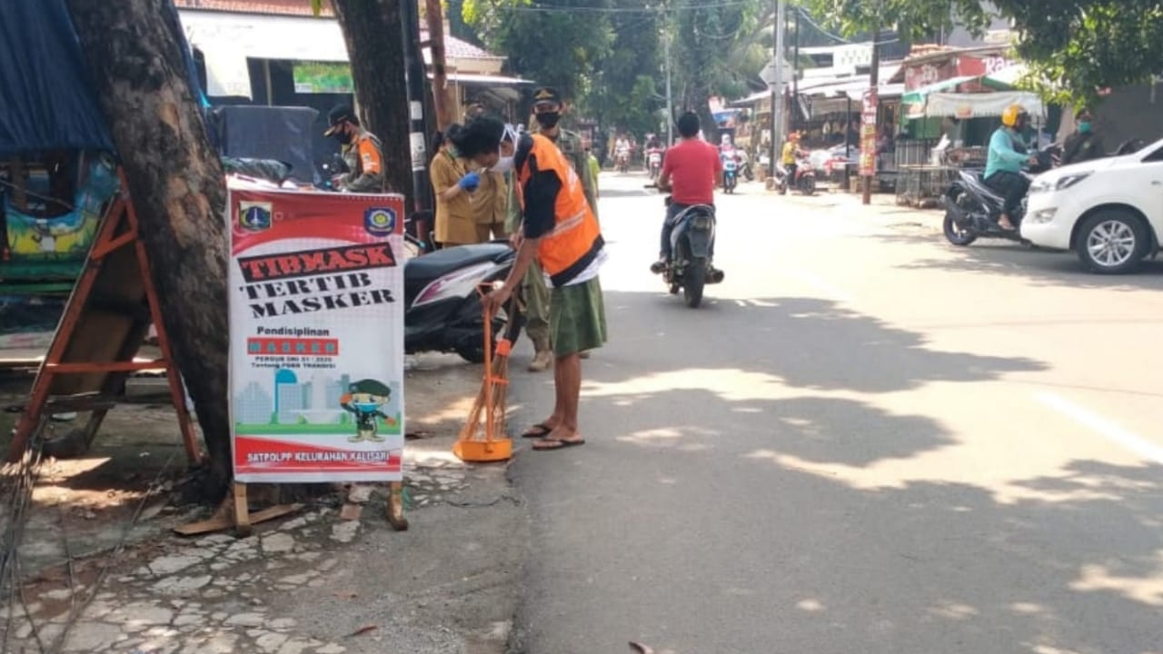 Terjaring Operasi TIBMASK, Warga Kelurahan Kalisari Disanksi Menyapu Jalan