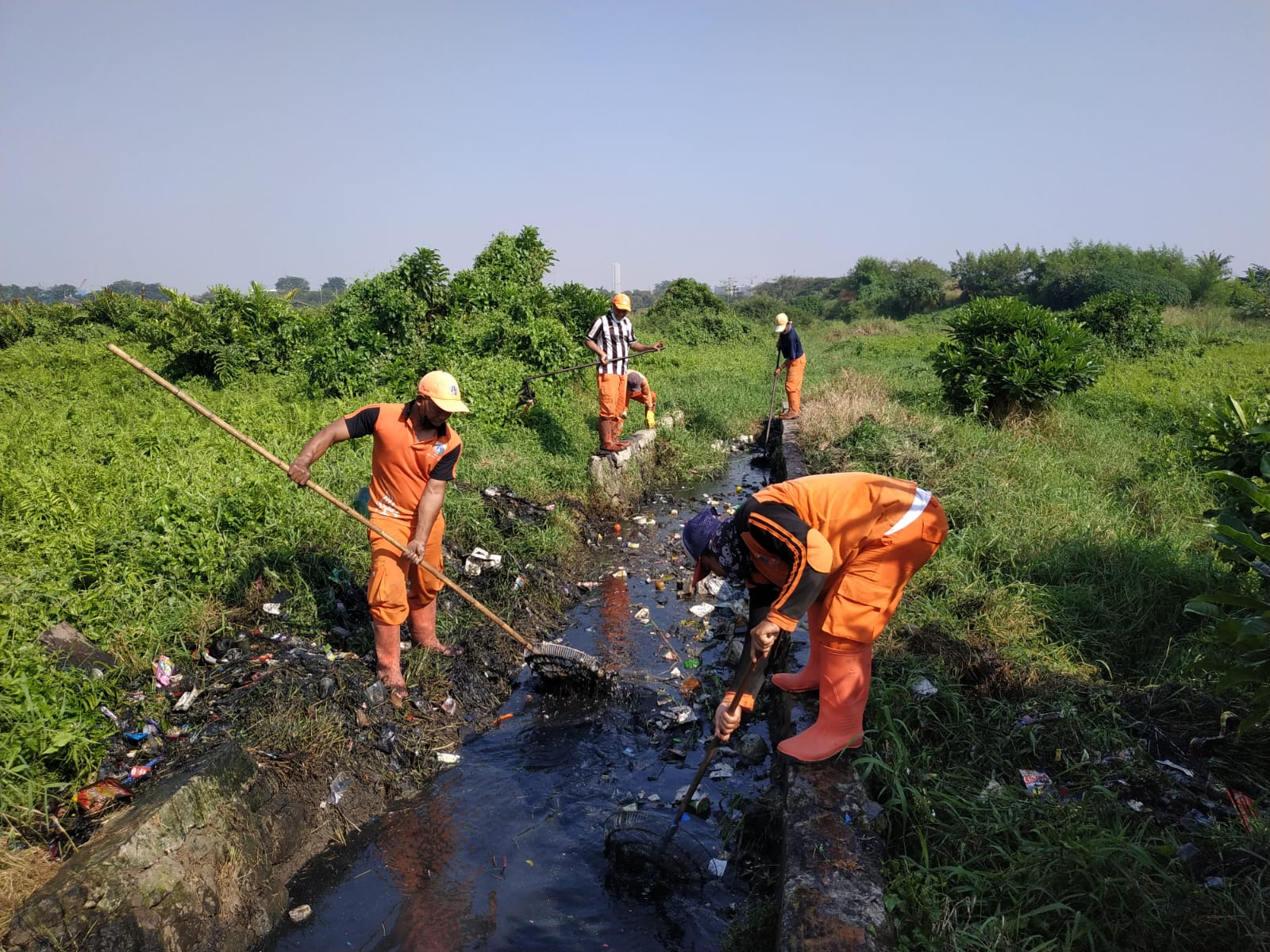PPSU Rapikan Rumput Liar di Saluran RW 12 Kelurahan Cakung Timur