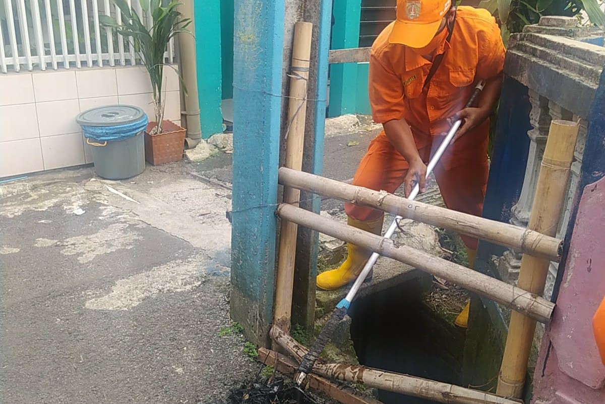 Petugas PPSU Kelurahan Ciracas Bersihkan Saluran Air Mampet
